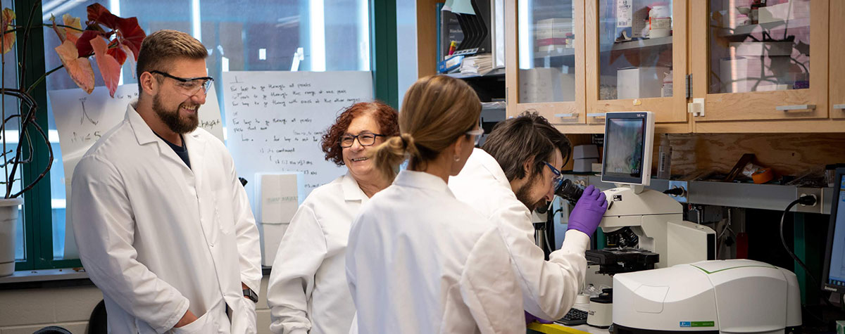 Graduate students and faculty mentor in lab