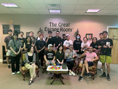 Students and staff posing with props in the lobby of the Great Escape Room, Providence, RI