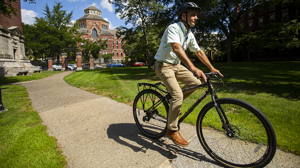 a man riding a bicycle around campus
