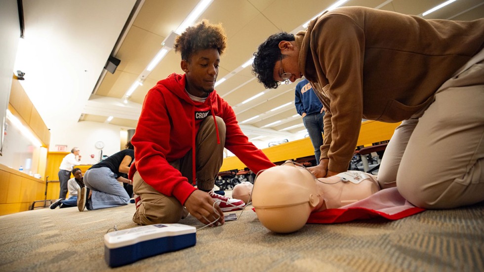 male students learning CPR during the Week of Medicine