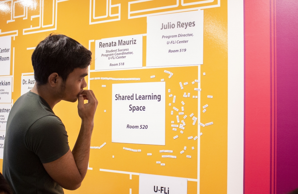 A YSEALI fellow studies a yellow display that reads "Shared Learning Space"