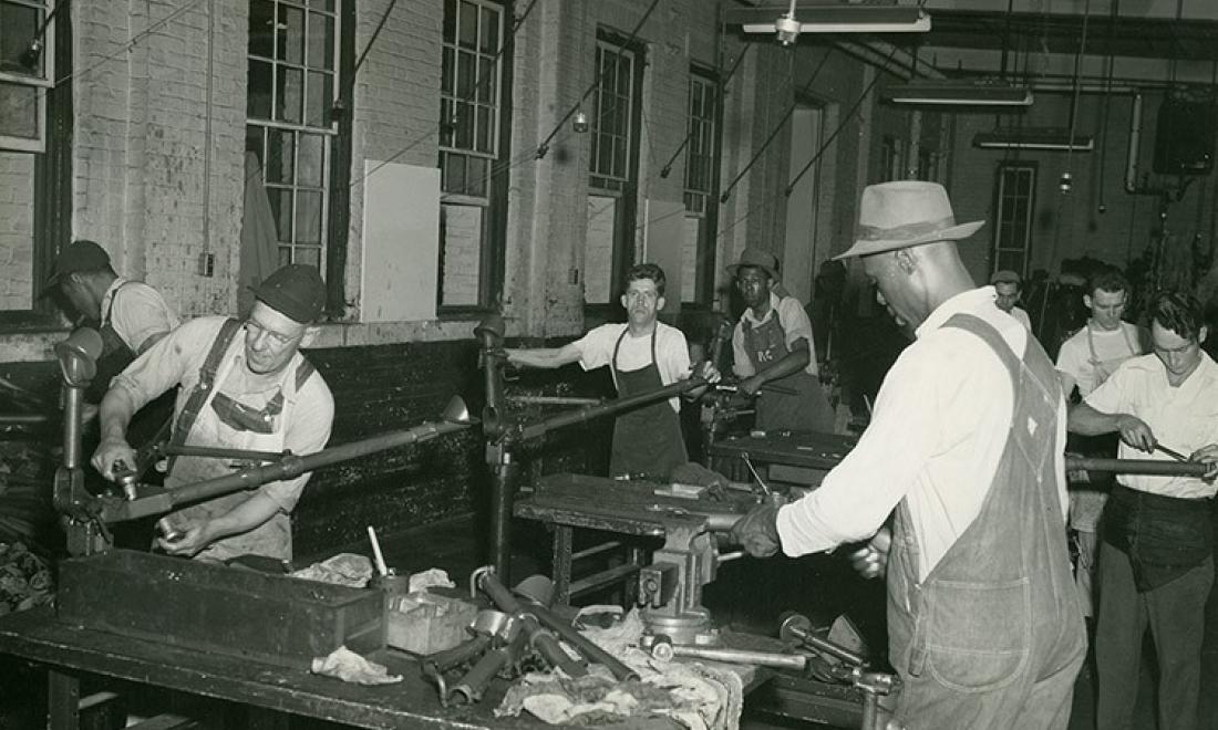 Photo of Black and white workers in a factory during WWII era