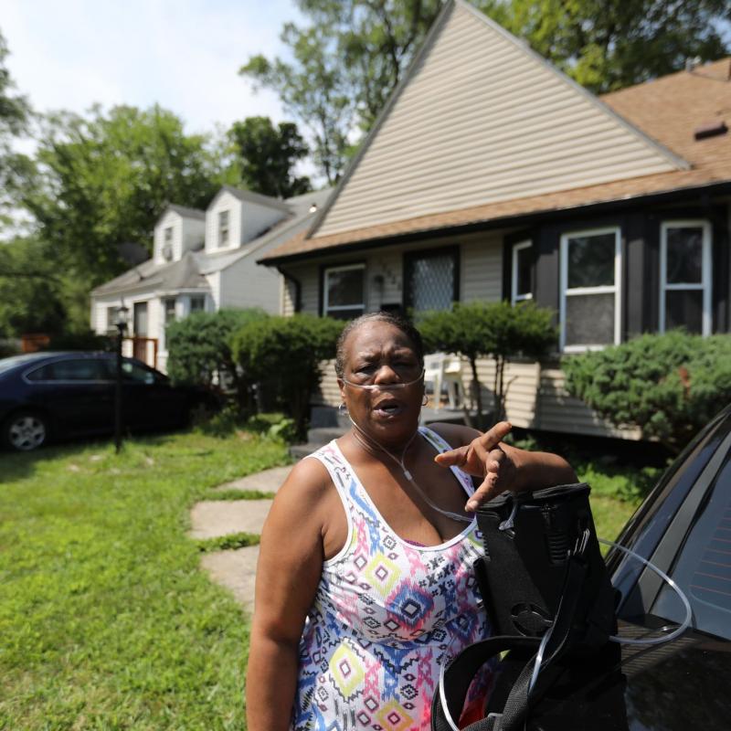 Woman stands in front of her home in Detroit
