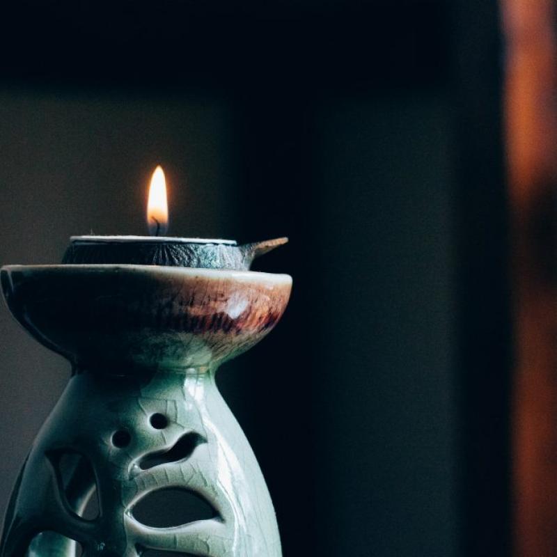 Photo of candle burning with dark, peaceful background