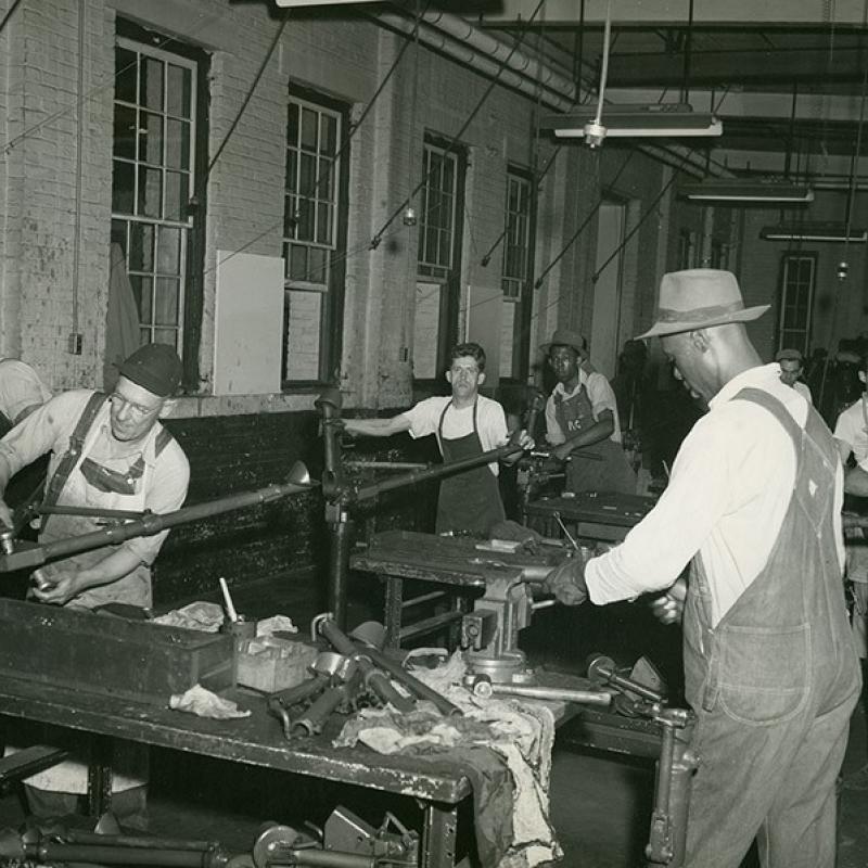 Photo of Black and white workers in a factory during WWII era