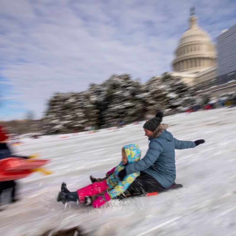 a mother and children sled near the US capital building