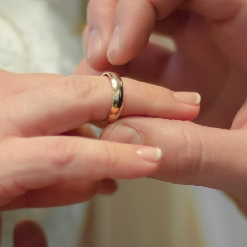 closeup of groom placing ring on bride's finger