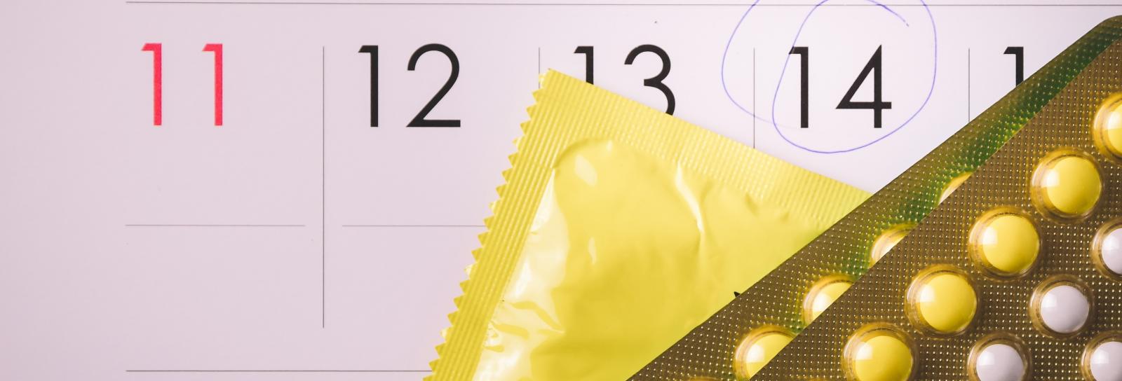 calendar with the 14th circled and packs of oral contraceptives