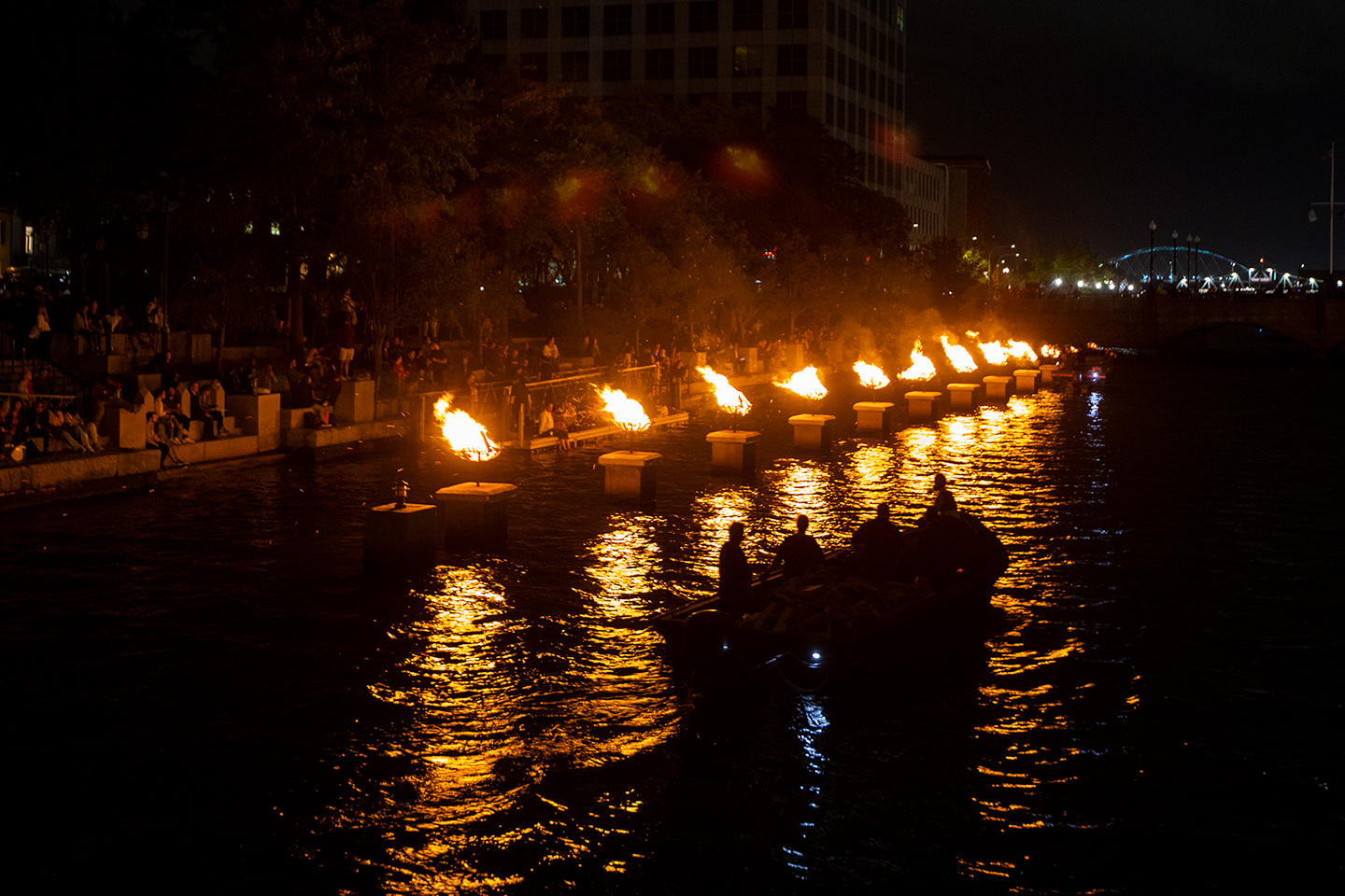 a boat approaching the waterfire floating fire pits