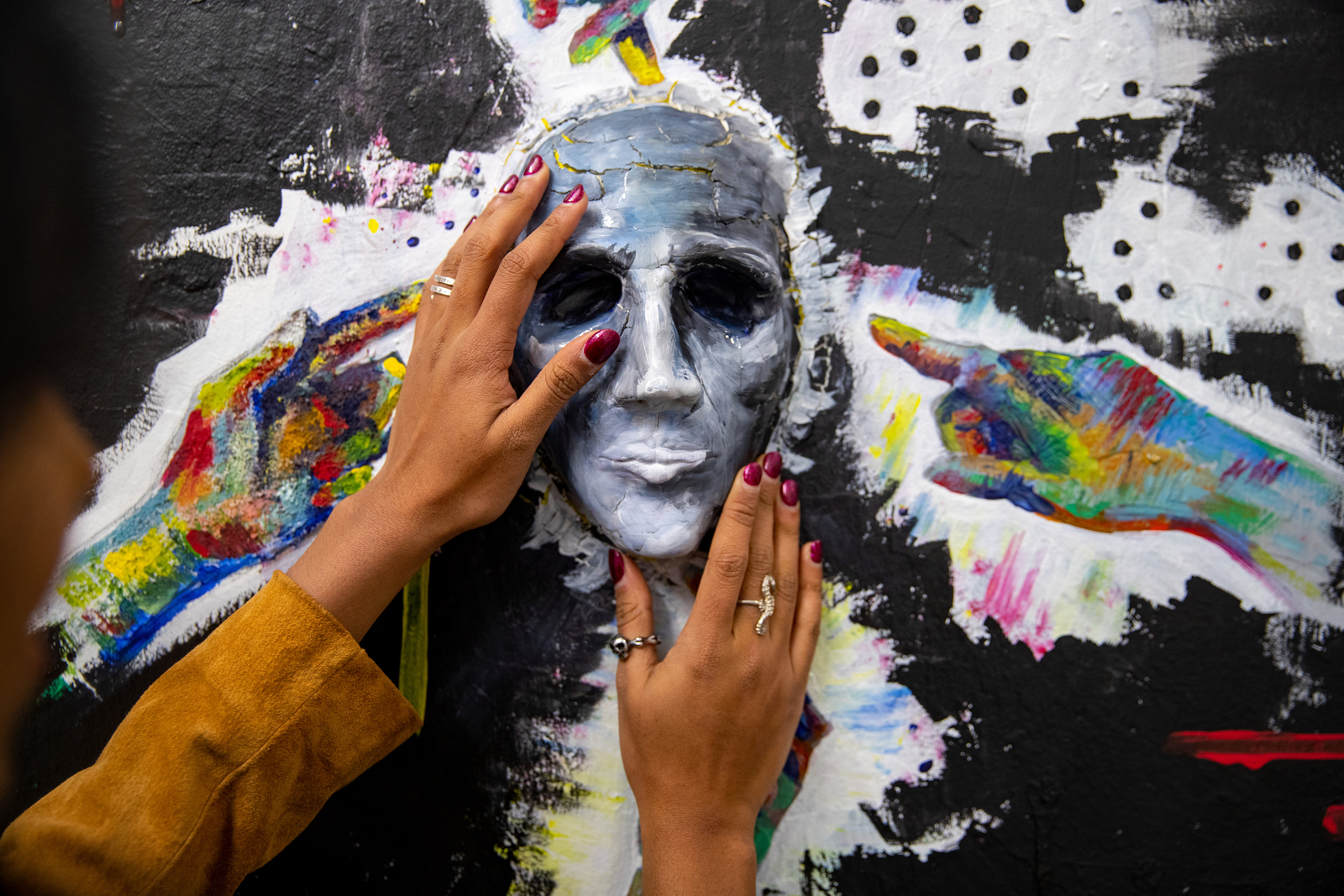 Rishika Kartik uses her hands to feel a tactile artwork she installed in the List Art Building stairwell