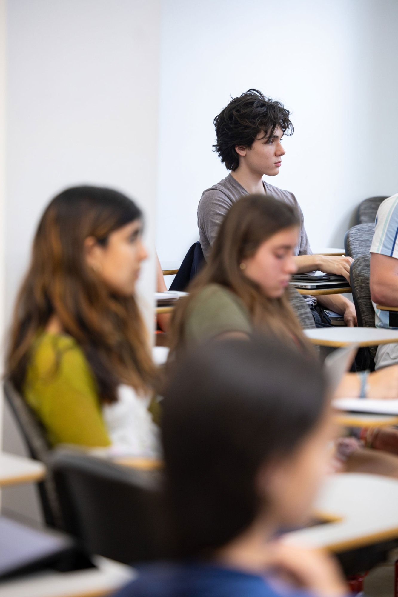 A student is in focus, sitting paying attention during class