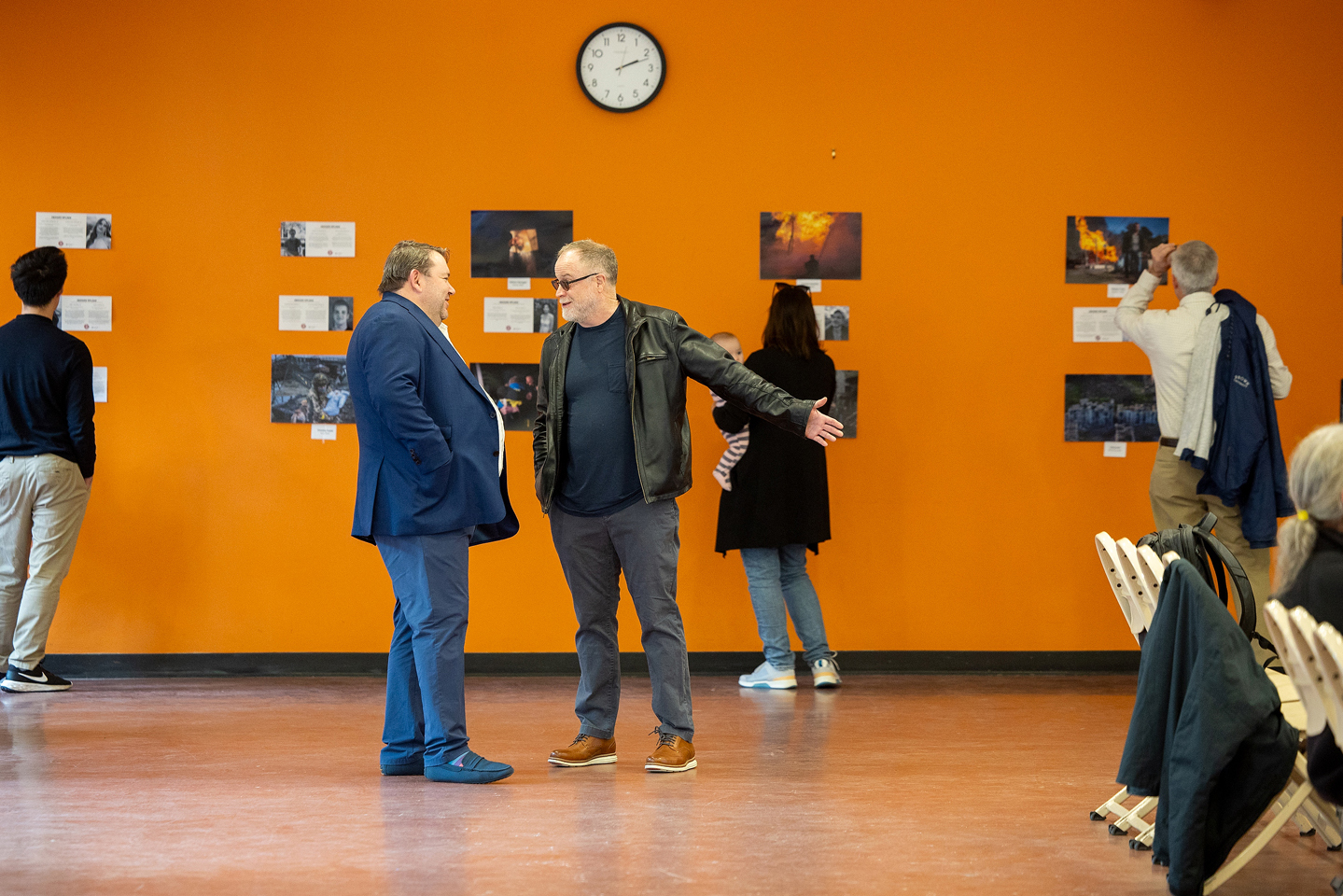 men talk in front of war photo exhibit