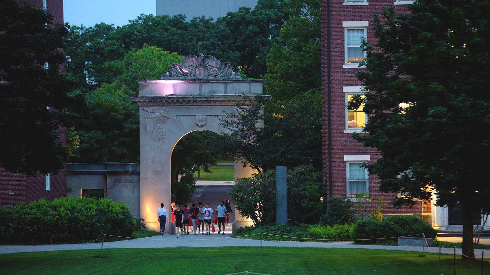 high schoolers walk through Brown's campus at dusk.