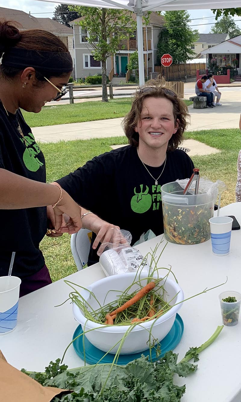 People sit at table handing out samples of veggies