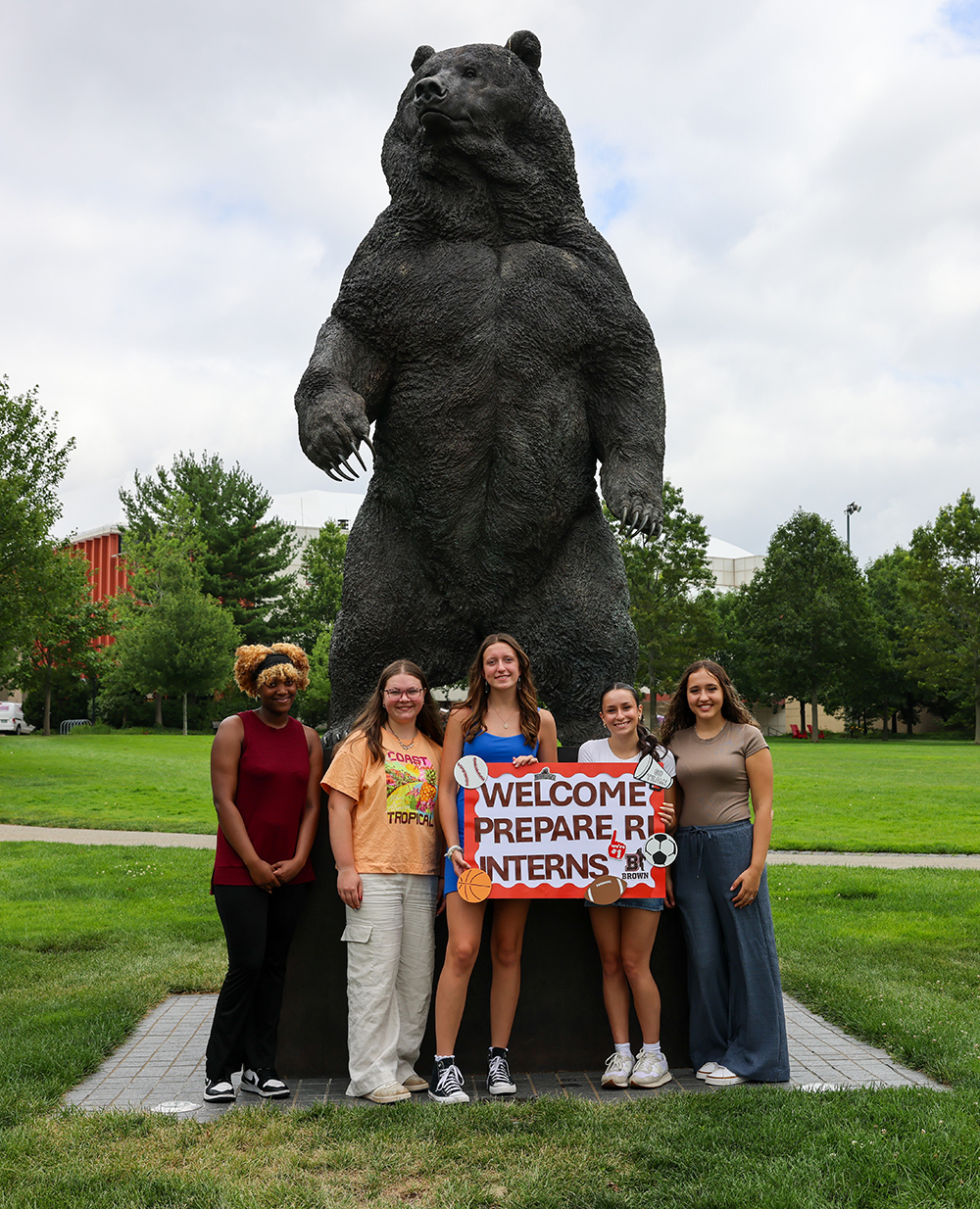 Local high schoolers take a photo together on Brown's campus in front of the University's mascot, Bruno the Bear, a statue