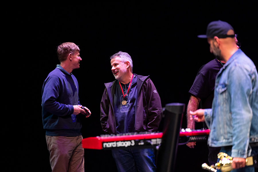 Brown employees smile and talk together after performing on the stage.