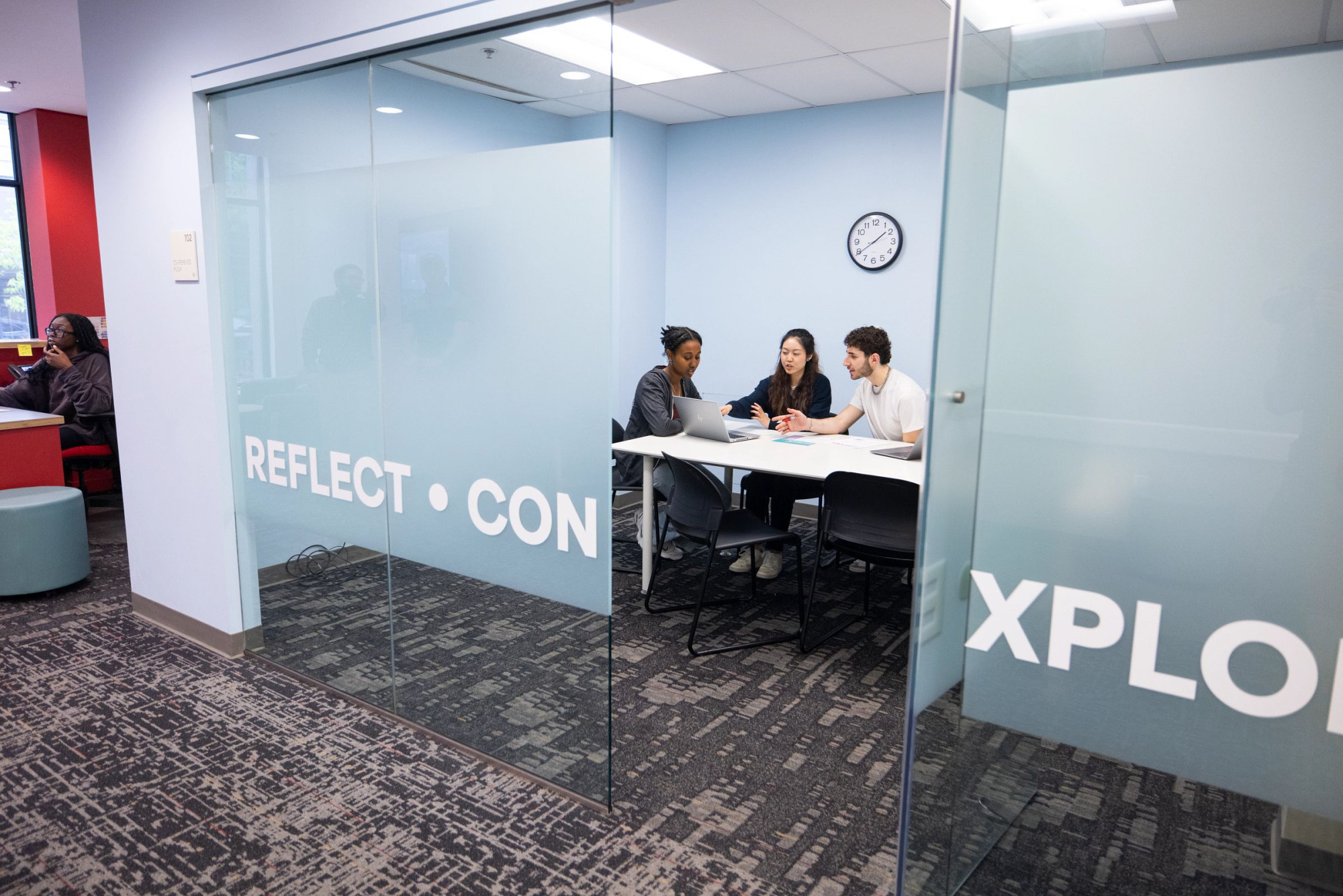 student discuss around a laptop