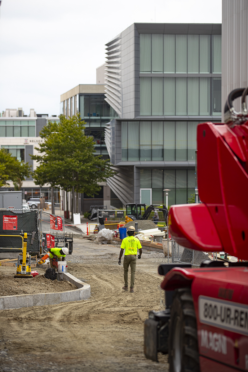 A local construction worker walks through a dirt path on a job site on Brown's campus.  