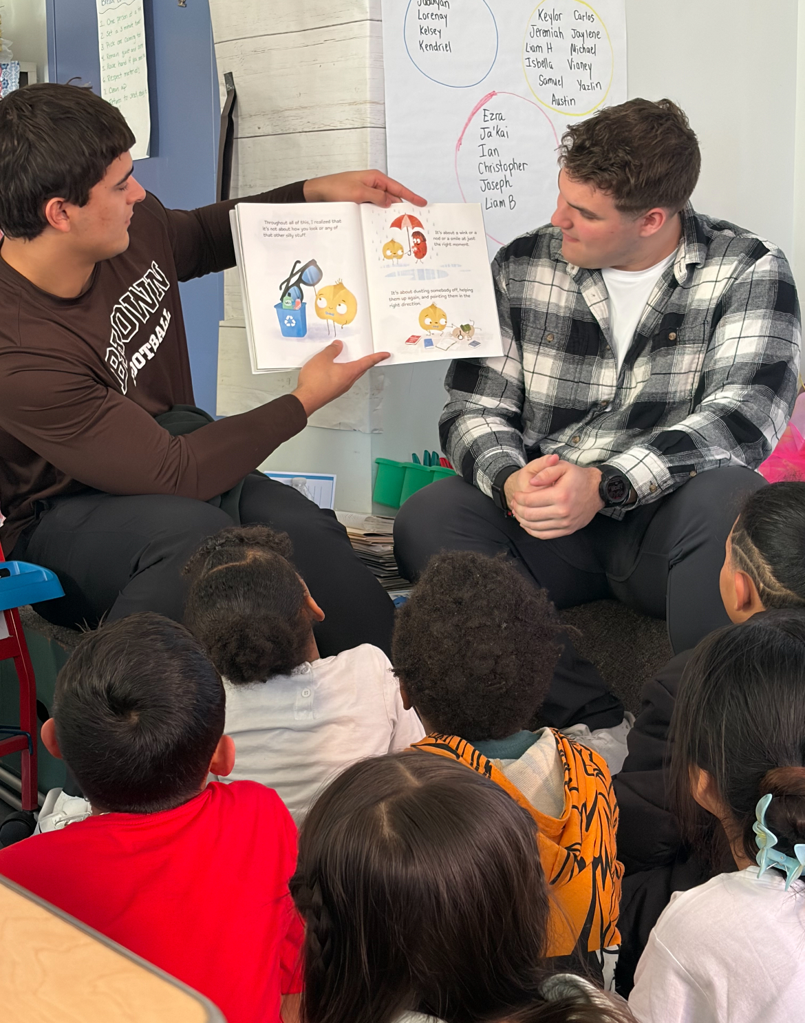 Brown football players read a book to kids in a Providence school.