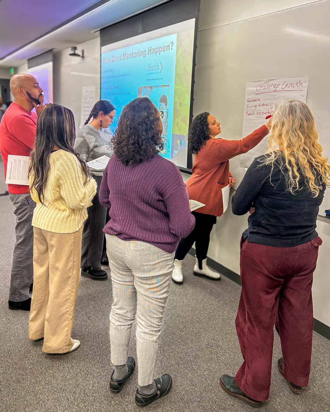 Brown staff work together in a exercise to strengthen mentorship skills. 