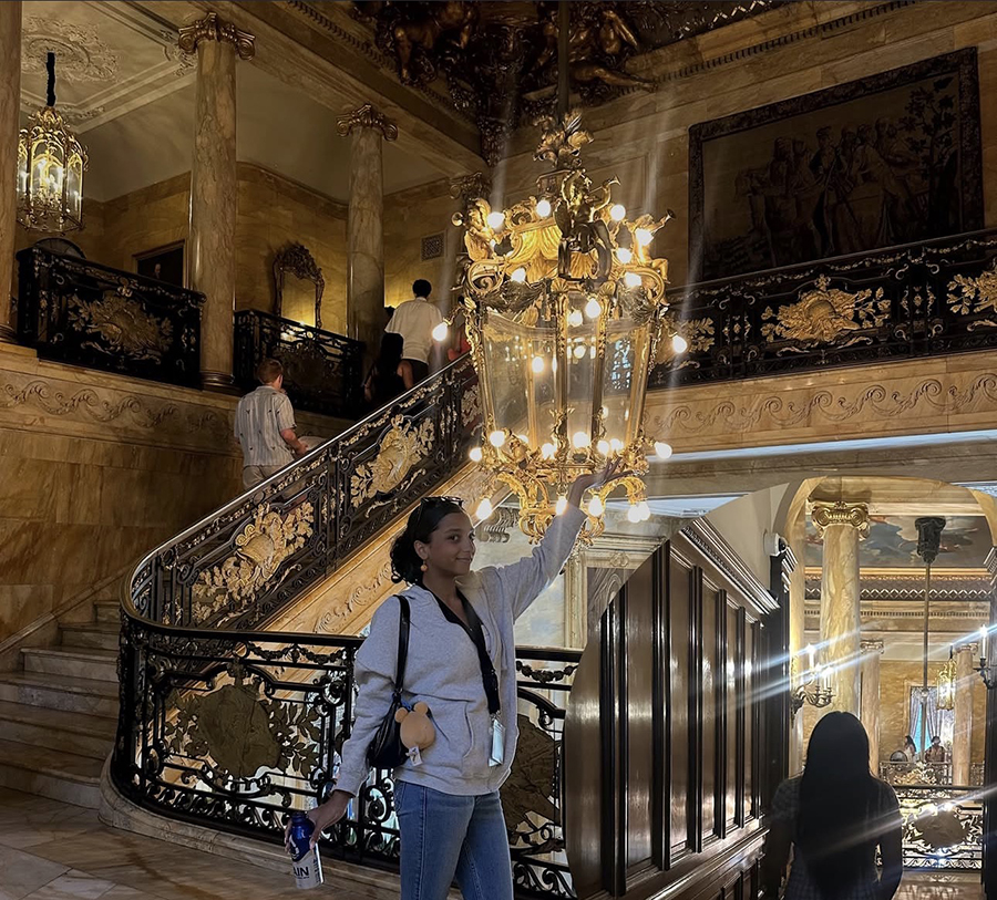 A Providence teen stops to take a photo next to a chandelier at a newport manson. 