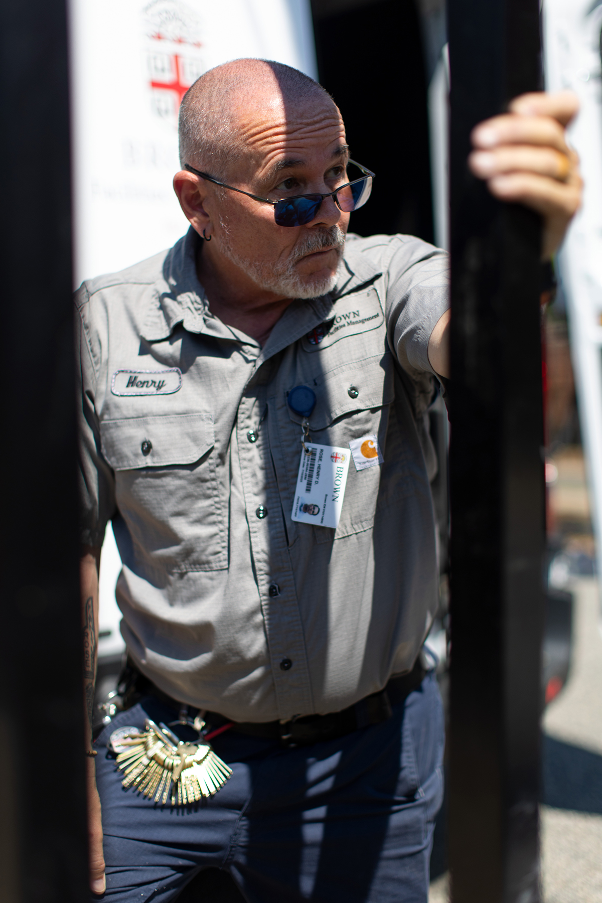 Brown staff member Henry Rose stands to hold a pole, erecting a new sidewalk sign.