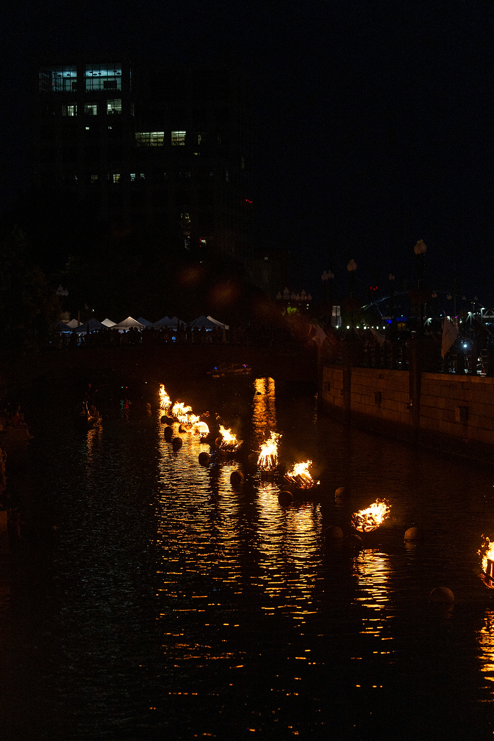 bonfires burn in the center of the providence river as part of waterfire providence