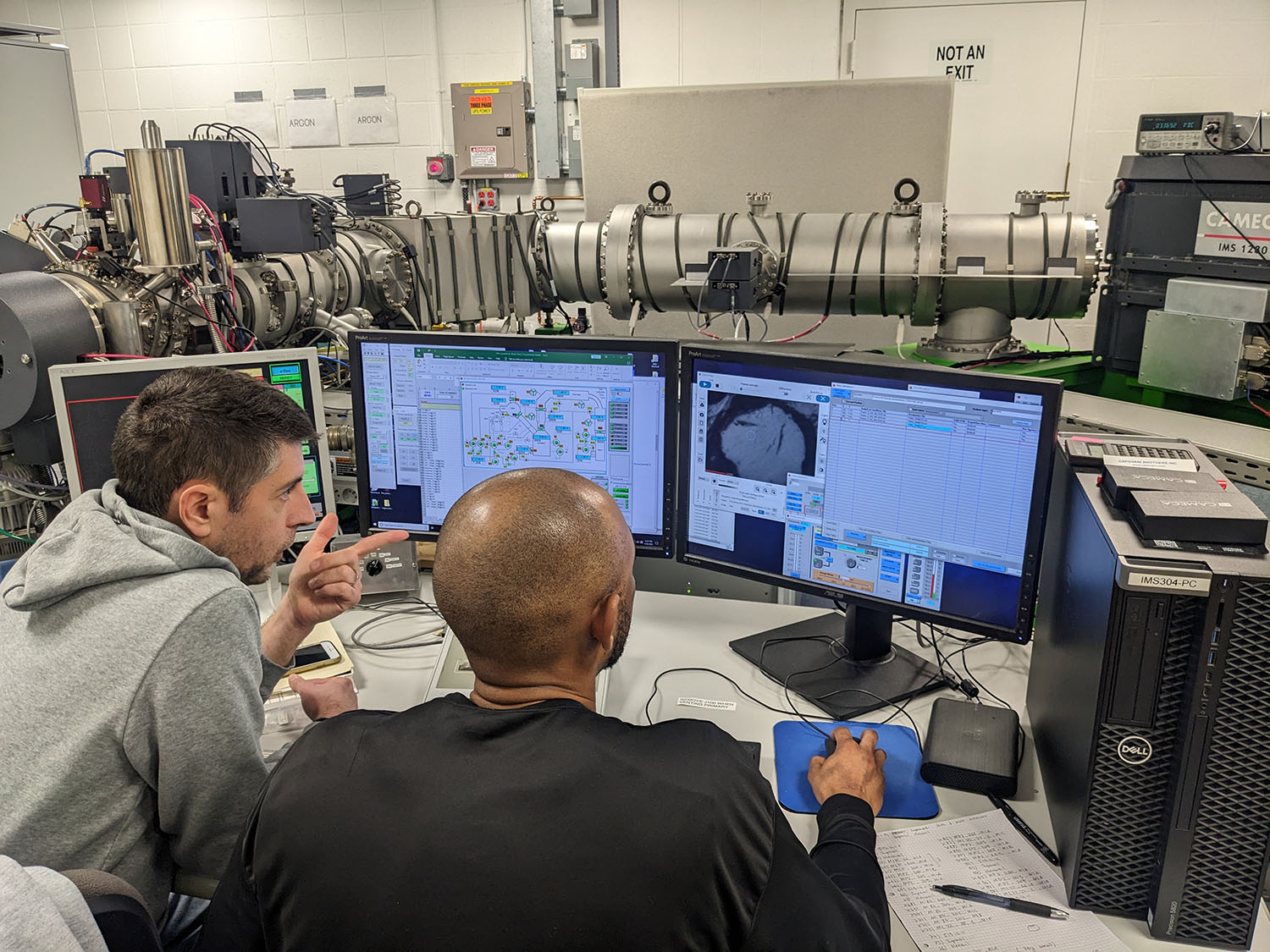 Two scientists analyze data on a computer screen