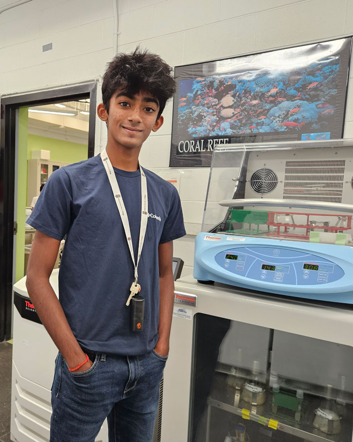 Eshaan Mandy stands in lab