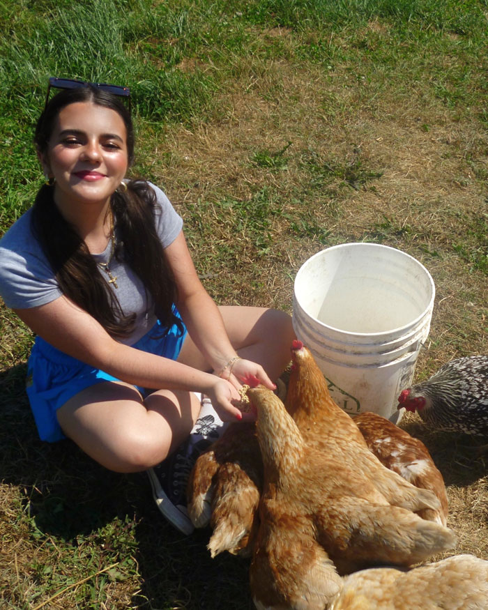 Eva Santelli holds chickens on a farm