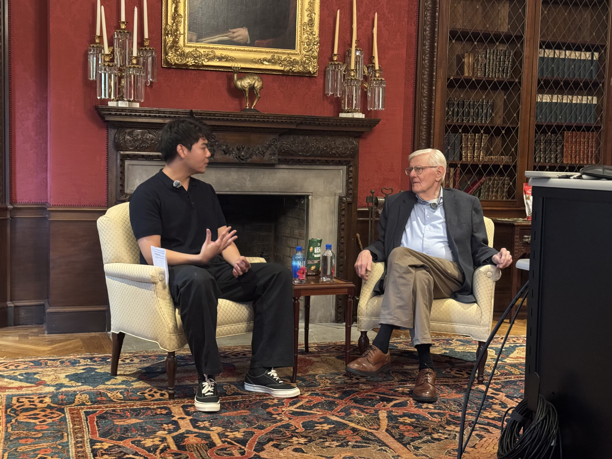 A student speaks with Gordon Wood sitting on sofa at Brown University