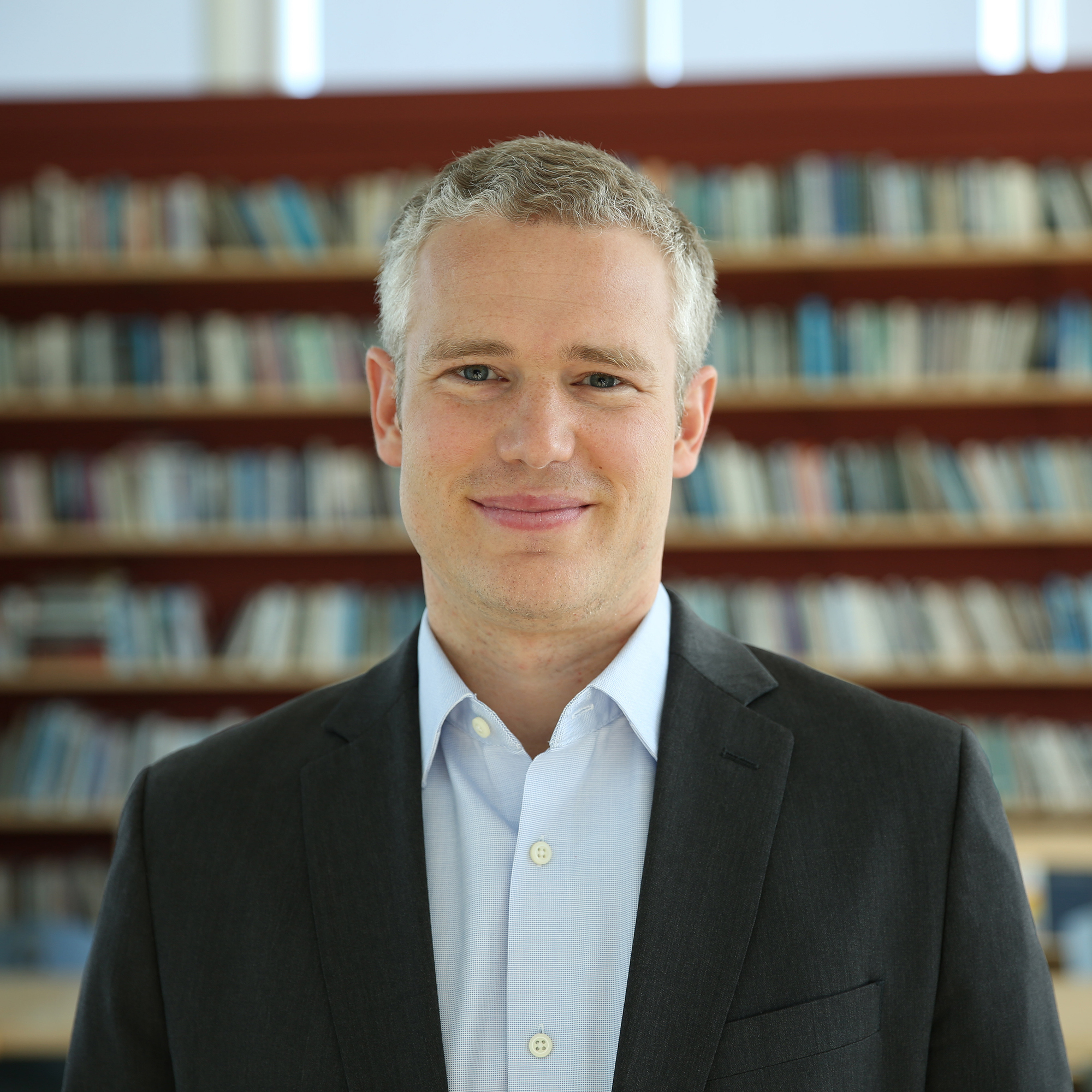 Matthew Kraft in front of a bookshelf