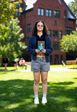 ailyn holds a framed photo of her as a preschooler