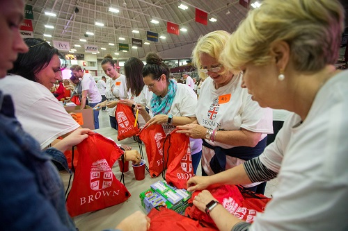 Employees stuff backpacks with school supplies for area children