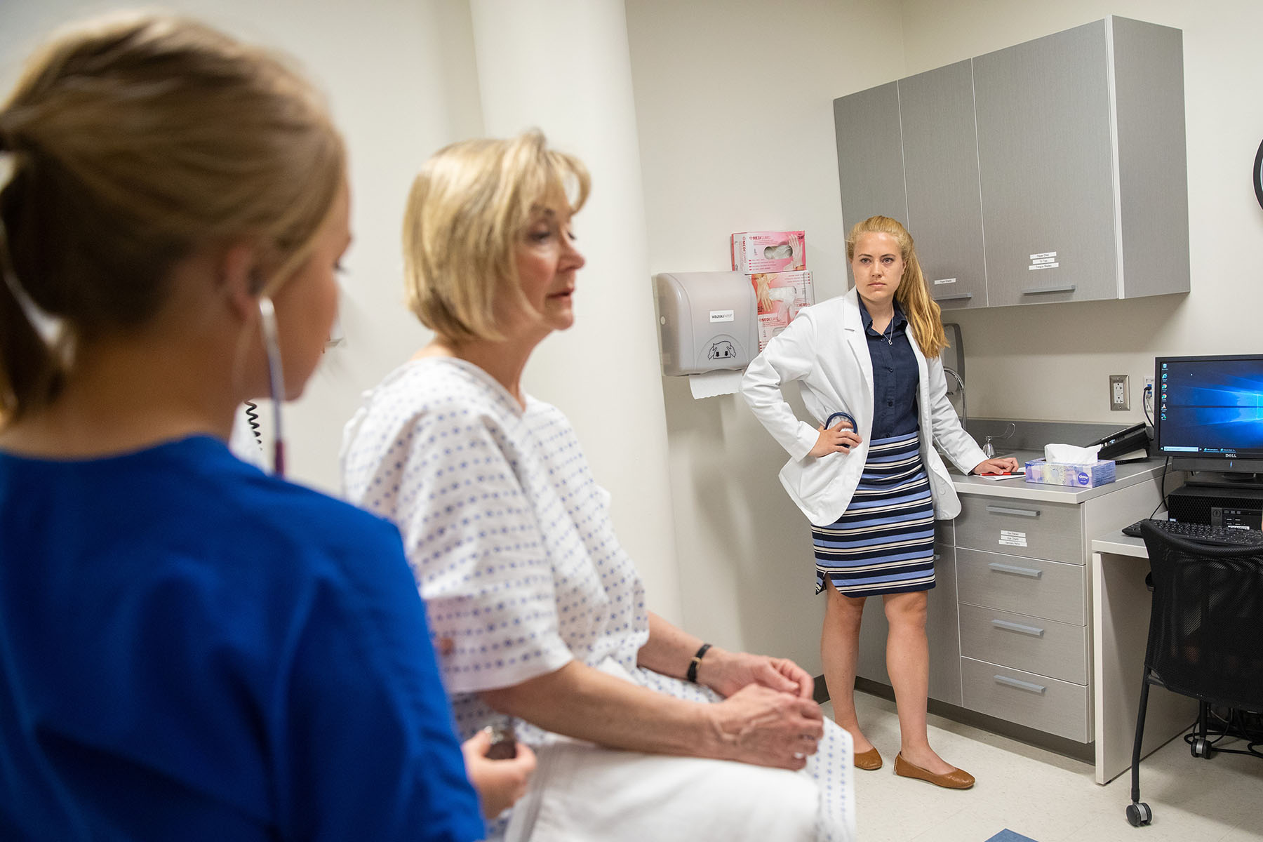 University of Rhode Island nursing student Julia Garibalid takes the vital signs of a standardized patient played by an actor during a workshop focused on opioid use disorders.