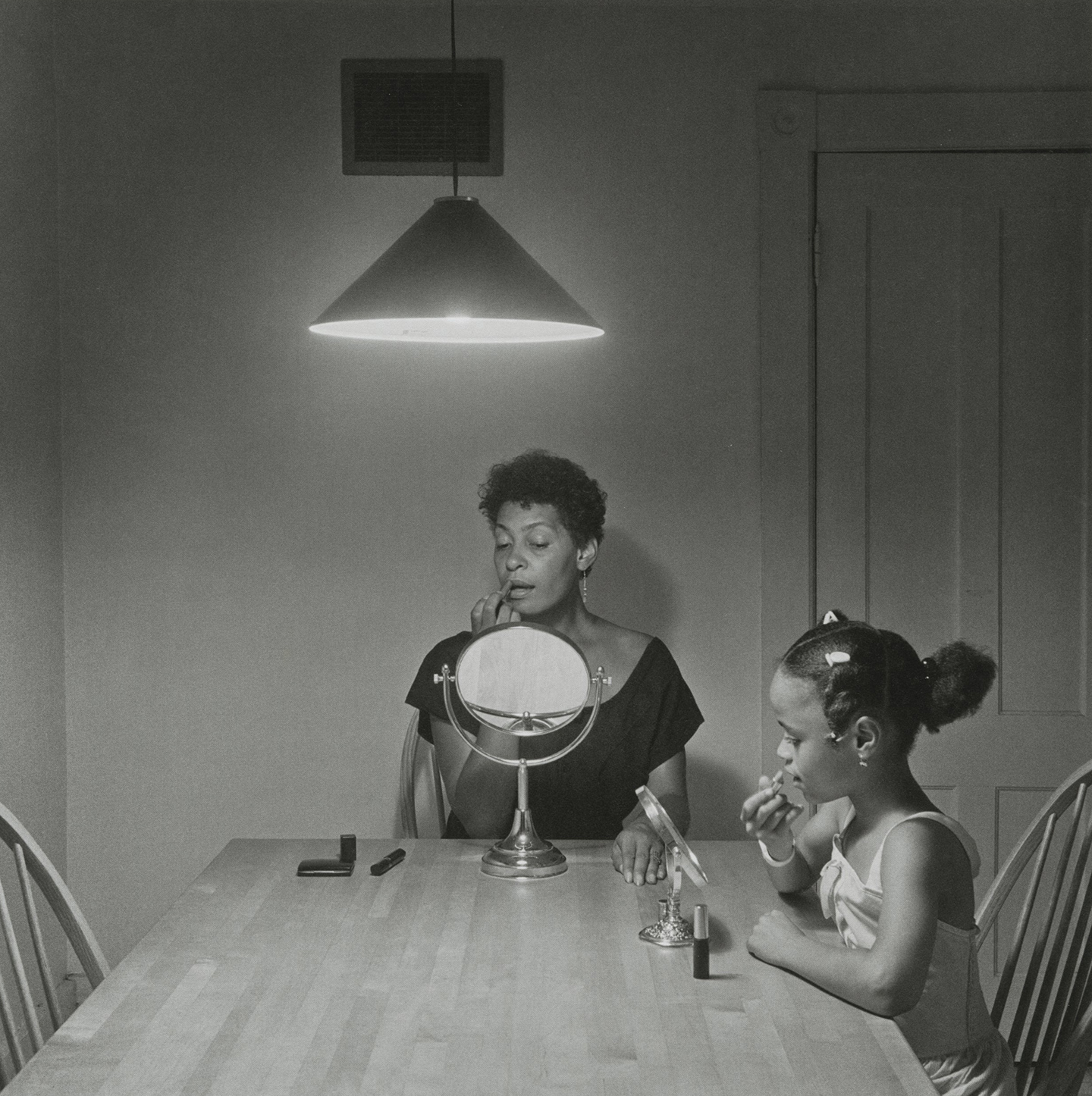 Untitled photograph of woman and daughter applying makeup by Carrie Mae Weems (b&w)