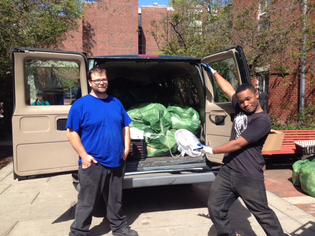 Two Brown students with bagged clothing donations in back of van