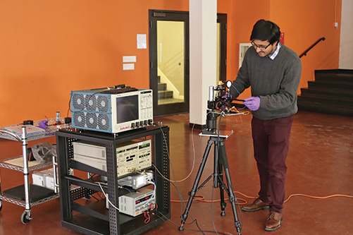 raduate student Rabi Shrestha works on terahertz testing equipment