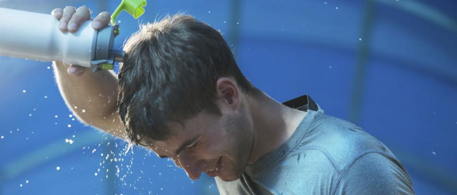 Man pouring water on his head from sports bottle
