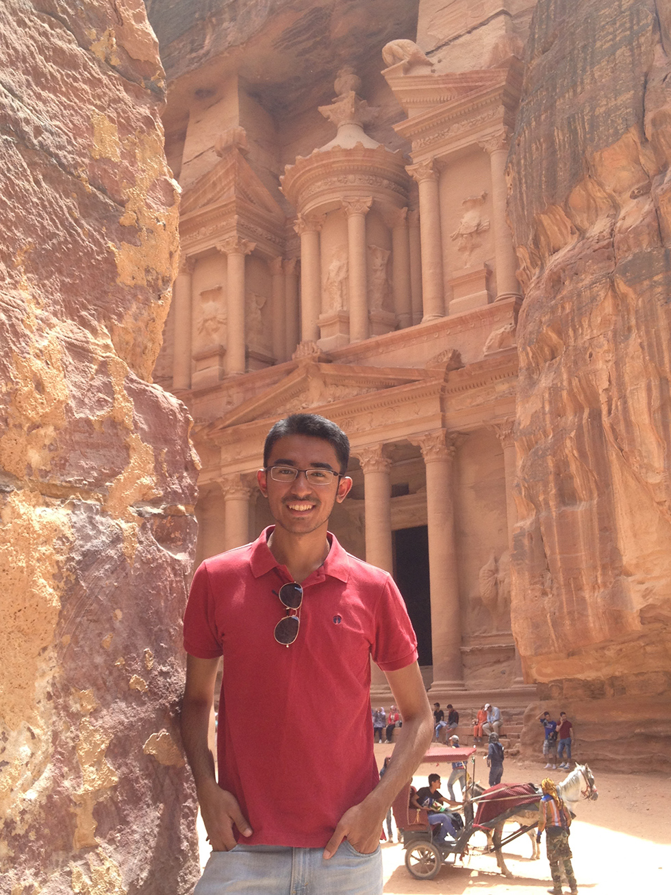 I Naishad Kai-ren standing in front of ancient architecture in Petra, Jordan
