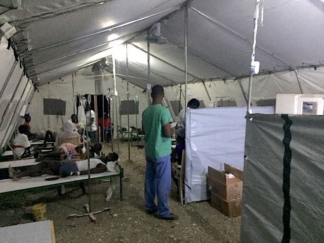 Patients and volunteers inside tent