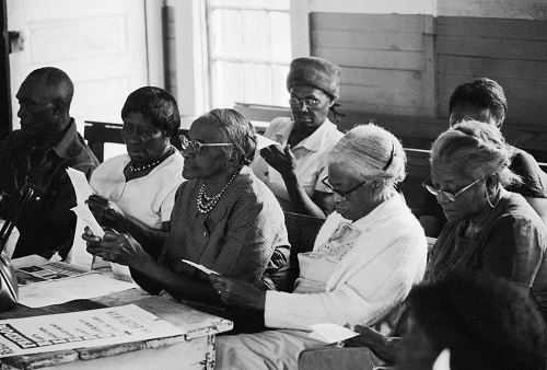 Black voters are reading sample ballots during a class