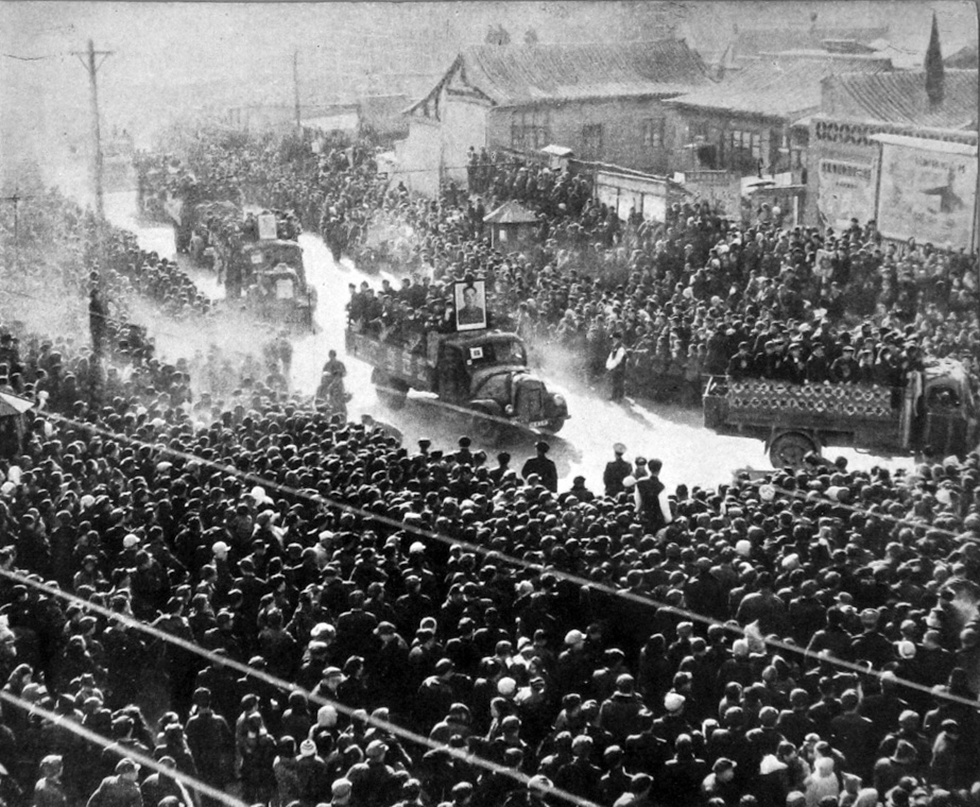 Trucks bearing the image of Mao Tse Tung drive through Chinese streets packed with onlookers (black and white)