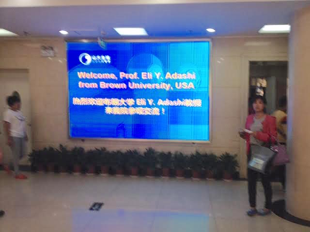Screen showing slide welcoming Dr. Adashi to the Shandong University teaching hospital
