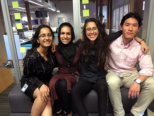 Hasan posing with three other interns