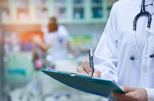 Doctor writing on clipboard