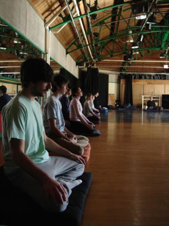Group of people meditating in a gym