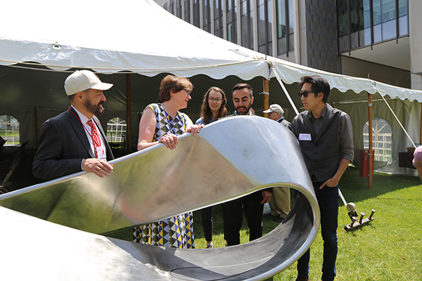 Brown students and administrators admire the sundial sculpture