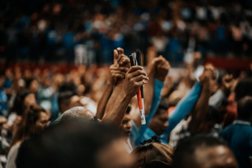 people holding hands in a crowded stadium