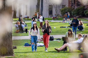 Students chat as they walk together on the College Green